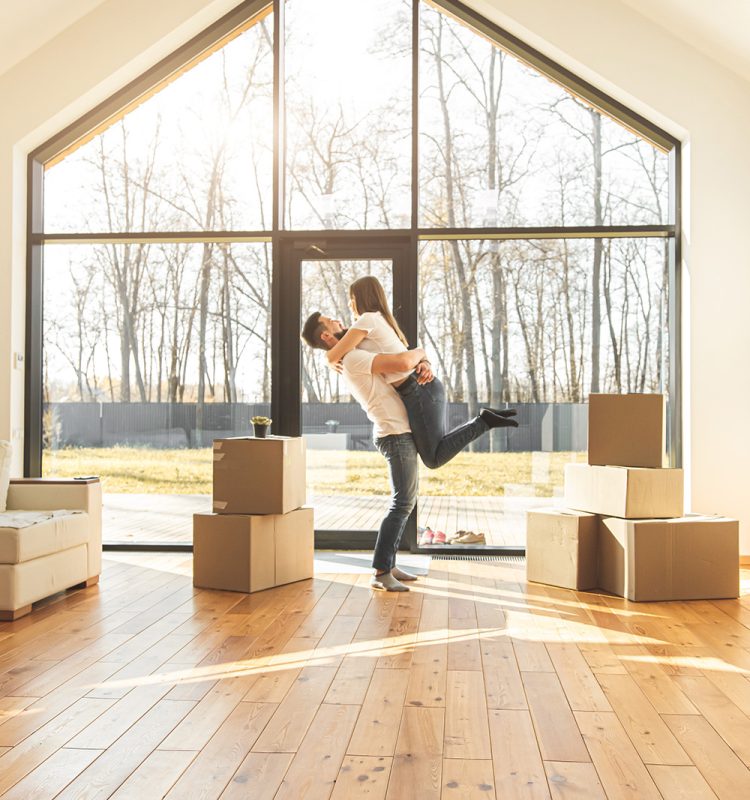 young couple moves to a new home. the family carries boxes of things after buying a home